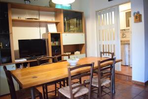 comedor con mesa de madera y sillas en Appartamento Letojanni Gabbiano Sul Mare, en Letojanni