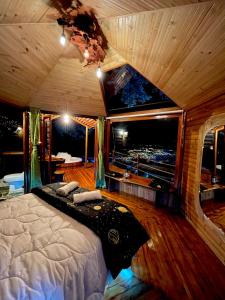 ein Schlafzimmer mit einem Bett in einem Zimmer mit einem großen Fenster in der Unterkunft Senderos Glamping in Villavicencio