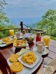 a table topped with plates of breakfast foods and drinks at Senderos Glamping in Villavicencio