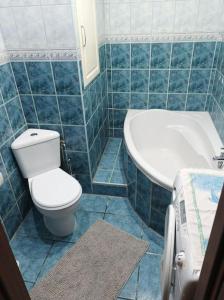 a blue tiled bathroom with a toilet and a sink at Byt v centre mesta Snina in Snina