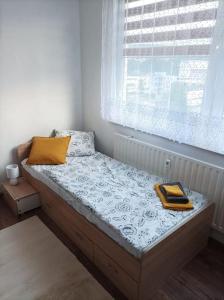 uma cama num quarto com uma janela em Byt v centre mesta Snina em Snina