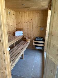 a wooden sauna with two benches and towels in it at Greentrees Estate -The Oak Suite in Haywards Heath