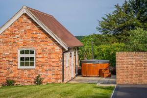 a brick house with a trash can in the yard at Greentrees Estate -The Oak Suite in Haywards Heath