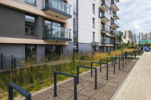 a row of benches in front of a building at Apartment Starowiejska with Balcony & Parking next to Gdańsk Arena Stadium by Renters in Gdańsk