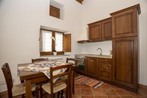 cocina con mesa, fregadero y fogones en Arcaloro Resort, en SantʼAngelo di Brolo
