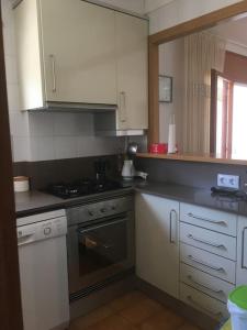 een keuken met witte kasten en een fornuis met oven bij Apartament amb vistes in Platja  d'Aro