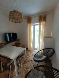 ein Wohnzimmer mit einem weißen Tisch und Stühlen in der Unterkunft Casa Valsecca in Krk