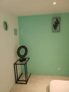 a room with a table and a clock on a wall at Appartement charmant américain in Hardricourt