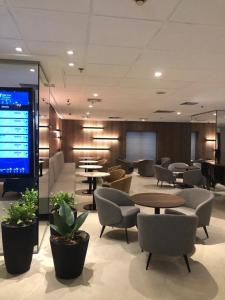 eine Lobby mit Tischen und Stühlen und einem großen Bildschirm in der Unterkunft Blue Tree Premium Faria Lima in São Paulo