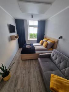 um quarto com uma cama e um sofá em Apartament Lux Lemon em Jelenia Góra