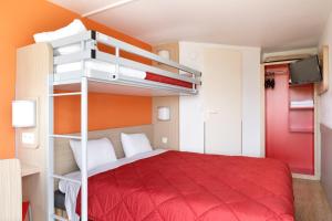 Un dormitorio con una cama roja y literas. en Première Classe Châlons-en-Champagne, en Châlons-en-Champagne