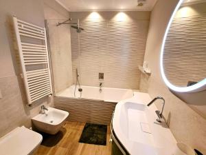 een badkamer met een bad, een wastafel en een toilet bij Casa Alpina- Praetoria Suite in Aosta