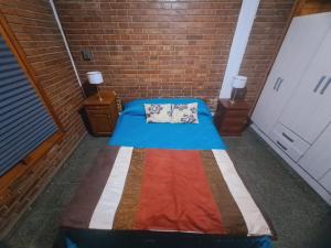 um quarto com uma cama numa parede de tijolos em Mendoza Urbano Confort em Mendoza