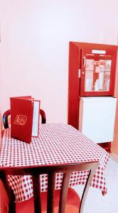 uma mesa vermelha com uma caixa vermelha ao lado de um frigorífico em Lips Motel (Adult Only) no Rio de Janeiro