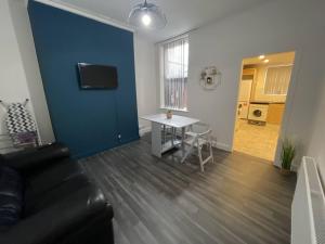 ein Wohnzimmer mit einem Sofa und einem Tisch in der Unterkunft Joyous Private Room in City Centre in Liverpool