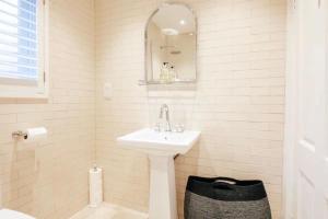 Baño blanco con lavabo y espejo en BRIGHTON BEACH APARTMENT Parking Free On-site en Brighton & Hove