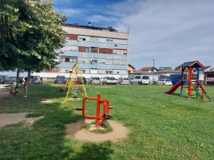 a park with playground equipment in front of a building at Apartman Kokin Grad in Prijedor