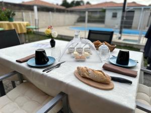 Le mas des anges في Soussans: طاولة بيضاء عليها صحون طعام
