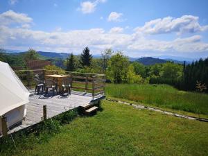 a wooden deck with a table and chairs on it at Sous les Toiles de PauTiLou in Molles