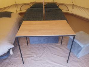 - une table dans une tente avec un lit dans l'établissement Sous les Toiles de PauTiLou, à Molles