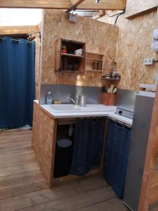 una cucina con lavandino e piano di lavoro di Sous les Toiles de PauTiLou a Molles
