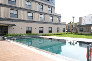 a swimming pool in front of a building at Grand Müdüroğlu Hotel in Aydın