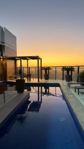 a swimming pool with a view of the ocean at sunset at Mercure Belem Boulevard in Belém