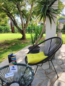 2 sillas con almohadas amarillas en el patio en Sleep & Fly Malpensa en Case Nuove