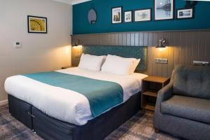 a hotel room with a bed and a chair at Almondsbury Inn & Lounge in Almondsbury