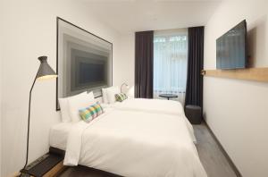 a white bedroom with a white bed and a television at Ibis Istanbul Airport in Istanbul