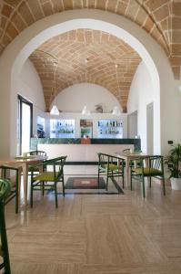 聖切薩雷亞泰爾梅的住宿－地中海大酒店，用餐室配有桌子和绿色椅子
