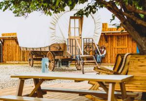 a man sitting on a bench next to a wagon at Big Texan Wagons in Amarillo