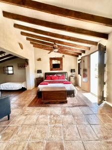 una camera da letto con un letto con cuscini rossi di Cortijo Cuscurro a Ríogordo