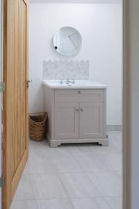 a bathroom with a sink and a mirror on the wall at Greentrees Estate - The Chestnut Cottage in Balcombe