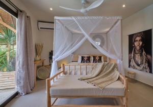 a bedroom with a bed with a canopy at Villa Chanalu in Ngaparou