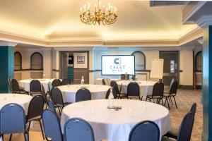 a conference room with tables and chairs and a screen at Almondsbury Inn & Lounge in Almondsbury