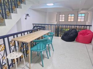 a room with a table and chairs and a staircase at Kong Khong Homestay in Hat Yai