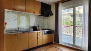 cocina con fregadero y ventana grande en Experience relaxation in Otaru's bungalow en Otaru