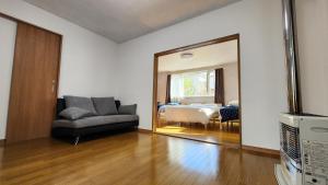 sala de estar con sofá y espejo en Experience relaxation in Otaru's bungalow en Otaru
