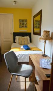 a bedroom with a bed with a desk and a chair at Old Palace Guest House in Brighton & Hove