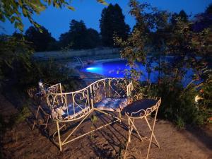 a wrought iron bench in front of a pool at night at Ferienhof "Zum Spreewäldchen" in Burg