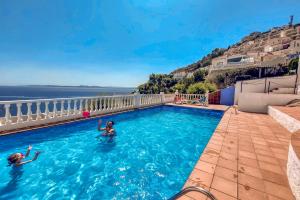 twee personen zwemmen in een zwembad met uitzicht op de oceaan bij Ibiza Bramer 11 Canyelles Roses - Barneda in Roses