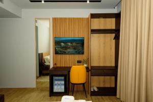 Cette chambre comprend un bureau et une chaise jaune. dans l'établissement KAAN Hotel, à Vlorë