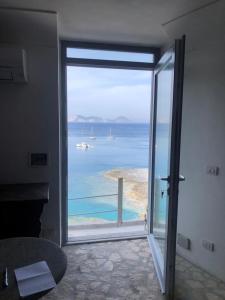 a room with a large glass door with a view of the ocean at Maridea - La Caletta - Luxury Villa in Ponza