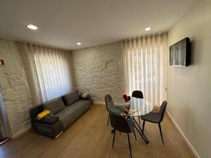 a living room with a couch and a table and chairs at Casa da Poça 2 - Guest House in Braga