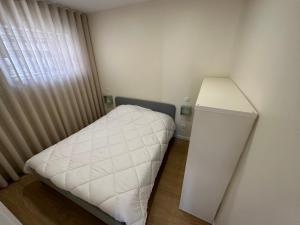 a small bedroom with a white bed and a window at Casa da Poça 2 - Guest House in Braga