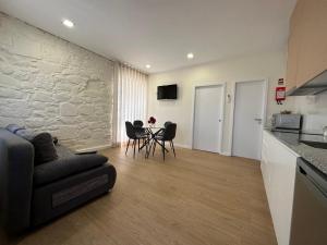 cocina y sala de estar con mesa y sillas. en Casa da Poça 2 - Guest House, en Braga