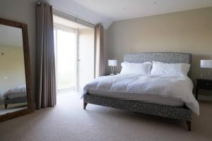 a bedroom with a bed and a large window at Greentrees Esate - The Ash Cottage in Haywards Heath