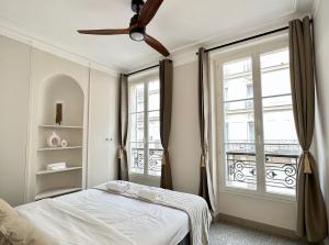 a bedroom with a bed and a ceiling fan at Charming Apartment with Eiffel Tower View in Paris