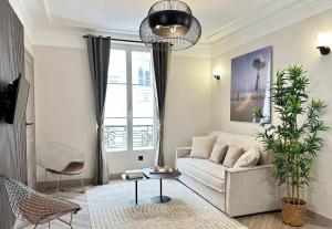 a living room with a couch and a table at Charming Apartment with Eiffel Tower View in Paris